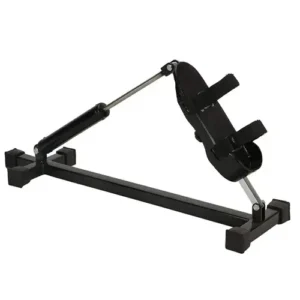 Product image of a compact leg and ankle exercise machine with an angled padded support, adjustable straps, and a metal resistance arm mounted on a stable rectangular base.